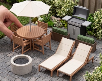 May include: Miniature outdoor patio furniture set including a round wooden table with a white umbrella, four chairs, two lounge chairs with white cushions, a gray grill, a circular fire pit, and two rectangular planters. DIGITAL STL FILES - NO PHYSICAL ITEM.