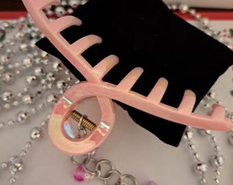 Pinza para el cabello con joyas, cadena dorada y dijes colgantes.