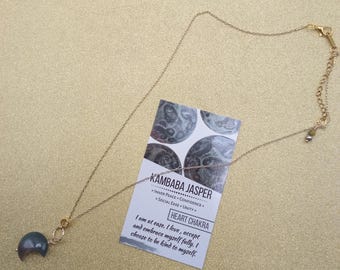 Pingente de jaspe em formato de lua crescente em corrente de ouro.