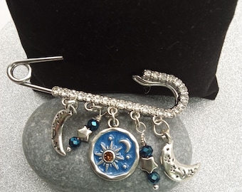 Broche celestial com alfinete de segurança em formato de lua e estrelas, com pingentes de strass.