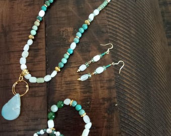 Conjunto de colar com pingente de quartzo (3 peças), 2 pulseiras elásticas e brincos.