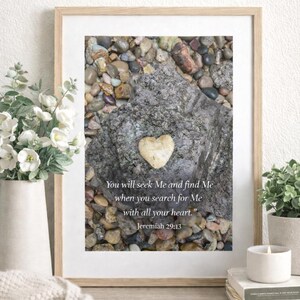 May include: A framed print featuring a heart-shaped stone on a larger rock, surrounded by pebbles. The print includes the text "You will seek Me and find Me when you search for Me with all your heart." Jeremiah 29:13.