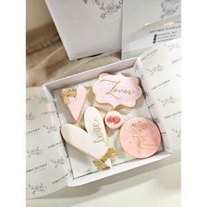 May include: A set of three ceramic mugs with a speckled, matte finish in cream, light grey, and dark grey. Each mug has a simple, minimalist design and a rounded handle.