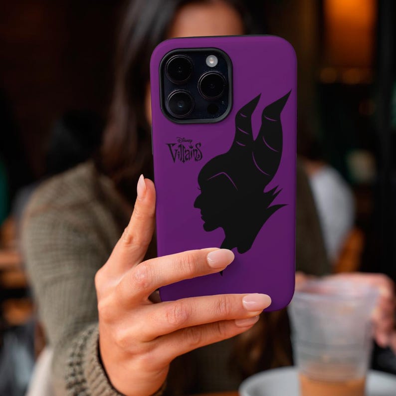 May include: A purple phone case featuring a black silhouette of a character's profile with horns, and the text "Disney Villains". The case has a glossy finish and a camera cutout.