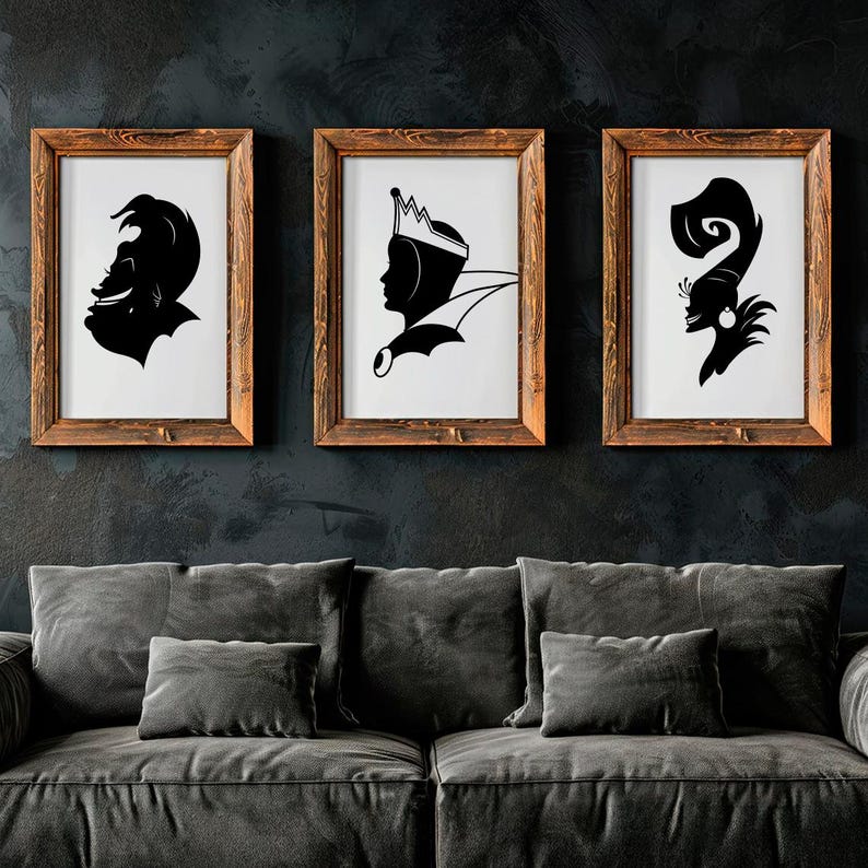 May include: Three framed black and white silhouette art prints. The prints feature stylized profiles of characters, each in a wooden frame. The artwork is displayed above a gray sofa against a dark wall.