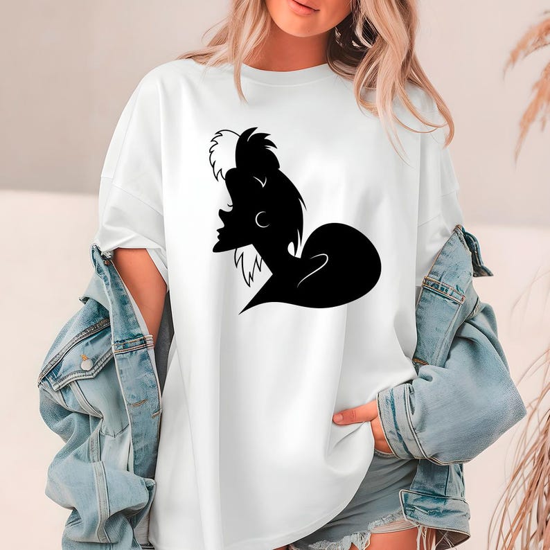 May include: White t-shirt featuring a black and white silhouette of a character with a distinctive hairstyle. The graphic is centered on the front of the shirt. The shirt is a casual, oversized style.