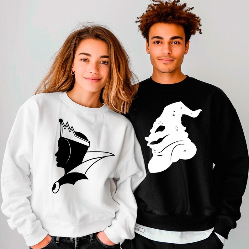 May include: Two sweatshirts, one white and one black, each featuring a silhouette graphic. The white sweatshirt displays a queen's profile with a crown. The black sweatshirt shows a whimsical character. Both are crew neck style.