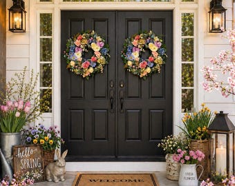 May include: A welcoming front door with two floral wreaths, flanked by lanterns and potted flowers. A welcome mat and a sign that says "hello SPRING" add to the spring theme. A decorative rabbit statue sits on the porch.