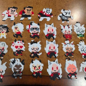 May include: A collection of pixel art figures, featuring various characters in a variety of poses. The figures are primarily black, white, and red, with some accents of other colours. The figures are arranged on a brown surface.