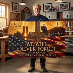 May include: A rectangular commemorative flag featuring a graphic of the Twin Towers, a bald eagle perched on a cross, and the American flag. Text reads: IN GOD WE TRUST, WE WILL NEVER FORGET, and SEPTEMBER 11, 2001, with three crosses on a hill.