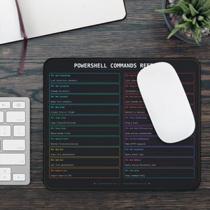 Op de afbeelding: Een zwarte rechthoekige muismat met een PowerShell Commands Reference-gids gedrukt in witte, blauwe, gele en rode tekst. De mat toont verschillende opdrachtregelinstructies in een rasterindeling met een witte computermuis bovenop.