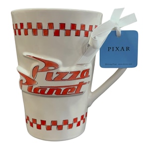 以下が含まれることがあります： 赤いPizza Planetのロゴが入った白いセラミックマグ。マグカップの上部と下部には赤と白のチェック柄があります。白いリボンで青いPixarタグが取り付けられています。