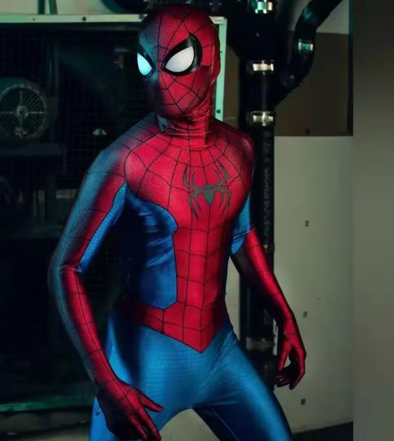 Pode incluir: Um traje vermelho e azul do Homem-Aranha. O traje apresenta um torso e cabe&ccedil;a vermelhos com um emblema de aranha preta no peito. Os bra&ccedil;os e pernas s&atilde;o azuis com detalhes de teia de aranha vermelha. A m&aacute;scara tem lentes brancas.