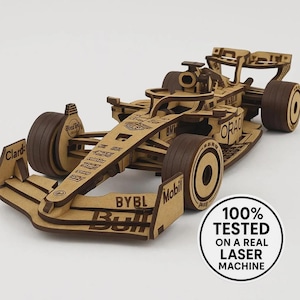 Könnte beinhalten: Ein Holzmodell eines Formel-1-Rennwagens. Das Auto besteht aus hellbraunem Holz mit dunkelbraunen Rädern und Akzenten. Das Modell verfügt über detaillierte Ausschnitte und Sponsorenlogos. Ein runder Aufkleber zeigt "100% GETESTET AUF EINER ECHTEN LASERMASCHINE."