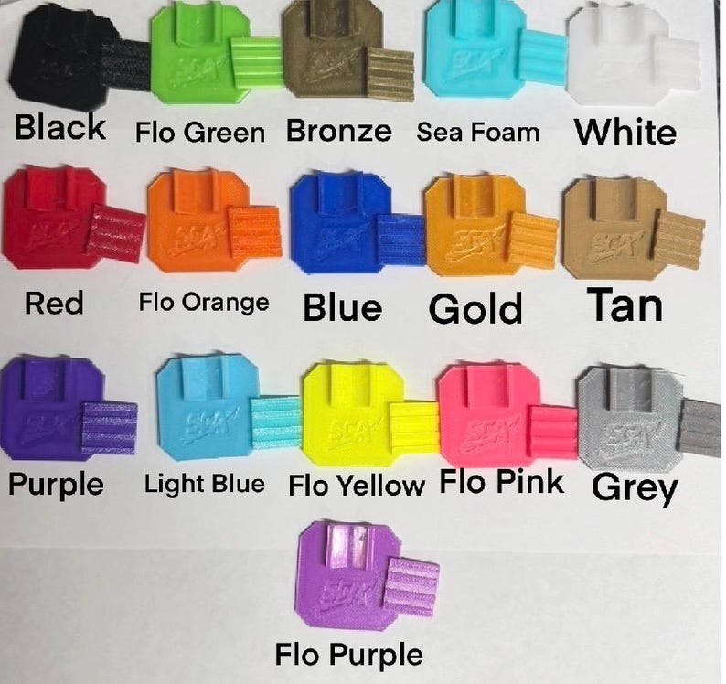Peut inclure: Une collection d'objets imprim&eacute;s en 3D de diff&eacute;rentes couleurs : noir, vert, bronze, &eacute;cume de mer, blanc, rouge, orange, bleu, or, beige, violet, bleu clair, jaune, rose et gris. Chaque objet a une forme unique, avec les noms de couleurs en dessous.
