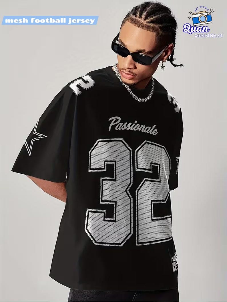 A man wearing a black mesh football jersey with the number 32, sunglasses, and a necklace.
