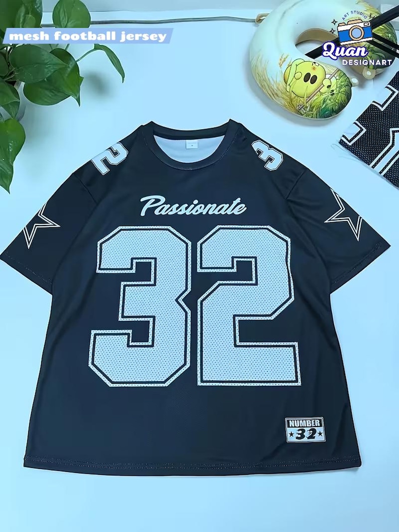 A black mesh football jersey with the number 32 and the word "Passionate" printed on it, along with a plant and a decorative item in the background.