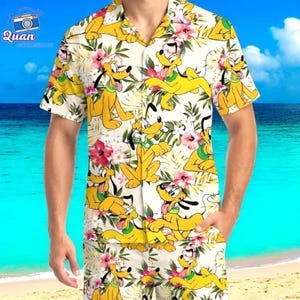 May include: A short-sleeved button-down shirt and matching shorts featuring a repeating pattern of the Disney character Pluto, yellow flowers, and green leaves on a cream background. The shirt has a classic collar and a relaxed fit.