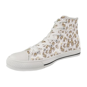 May include: High-top canvas sneaker with a white rubber sole and toe cap. The shoe features a repeating pattern of gold and white daisy flowers on a white background. White laces and a black stripe on the sole complete the design.