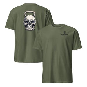May include: Olive green t-shirts with a skull-shaped kettlebell graphic on the back and the text "REPS & ROOTS" with a kettlebell logo on the front. The skull is white with black shading, and the text is black.