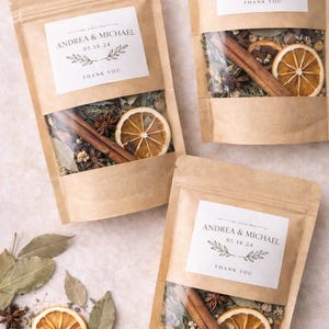 May include: Kraft paper pouches with clear windows, filled with dried herbs, spices, and a dried orange slice. Each pouch has a label that reads "ANDREA & MICHAEL 05.18.24 THANK YOU".