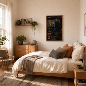 Puede incluir: Un p&oacute;ster vertical enmarcado colgado en la pared que muestra la silueta de un gato negro con corona y gafas, con el texto Princess Donut y Atrocity, en un dormitorio con estructura de cama de madera, almohadas y una c&oacute;moda.