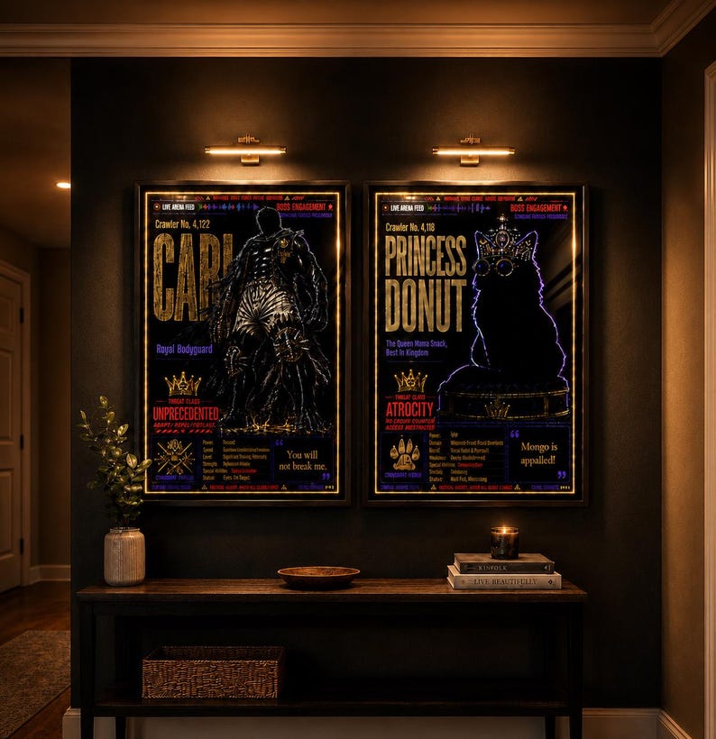 May include: Two framed vertical posters with black backgrounds and gold text. The left poster features a silhouette of a figure labeled Carl, Royal Bodyguard. The right poster shows a silhouette of a cat wearing a crown labeled Princess Donut.