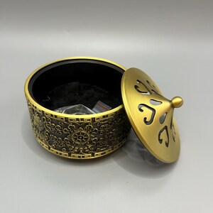 Incensário de latão com padrão sagrado em relevo, tampa vazada, porta-aromas, decoração espiritual para meditação.