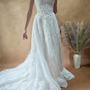 Vestido de novia de encaje con cintura vasca y sin tirantes imagen 1
