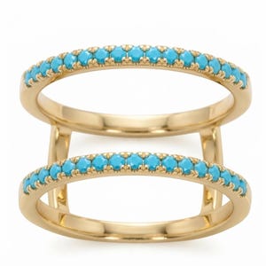 Peut inclure: Une bague à double anneau en or jaune poli, composée de deux bandes parallèles reliées par des barres verticales. Chaque bande est incrustée d'une rangée continue de petites pierres turquoise rondes et lumineuses serties en canal.