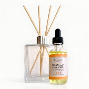 May include: A clear glass diffuser with wooden reeds and a small bottle of oil. The oil bottle has a black dropper and a label that reads "Polynesian Paradise - Smell the Happy!"