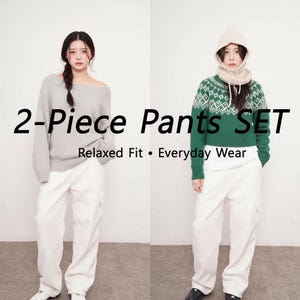 May include: Two-piece pants set in a studio setting. One model wears a gray off-the-shoulder sweater with white cargo pants. The other model wears a green patterned sweater with a hood and white cargo pants. Text on the image reads "2-Piece Pants SET" and "Relaxed Fit • Everyday Wear."