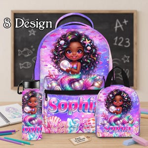 Op de afbeelding: Een set bestaande uit een rugzak, lunchtas en waterfles met een zeemeermin met een donkere huid en krullend haar die een parel vasthoudt. De items zijn versierd met een paars en roze onderwaterthema, schelpen en de naam Sophia in blauwe letters.