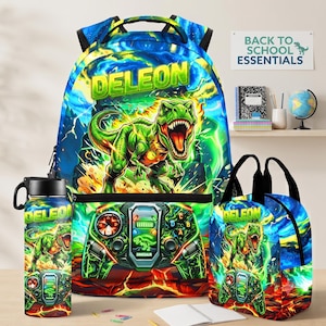 May include: A backpack, a water bottle, and a lunch bag set featuring a green T-Rex dinosaur, a video game controller graphic, and the name DELEON in yellow letters. The design includes blue and green lightning effects and a fiery orange base.