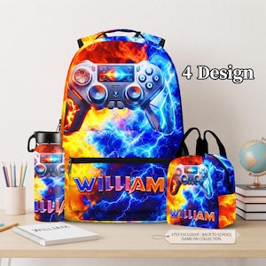 Peut inclure: Un sac à dos, une gourde et un sac à déjeuner avec un thème feu et glace, un motif de manette de jeu vidéo et le nom WILLIAM imprimé en orange et jaune. L'ensemble présente un motif d'éclairs bleu et orange vif.