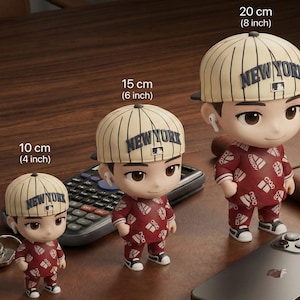 Puede incluir: Tres figuras de una persona con gorra de béisbol con texto "NEW YORK", un atuendo rojo estampado y zapatillas blancas. Las figuras miden 10, 15 y 20 cm de alto. Cada figura tiene una gorra de béisbol y lleva auriculares.