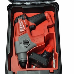 Pode incluir: Um kit de berbequim rotativo Milwaukee vermelho e preto numa mala rígida preta. A broca tem uma cabeça cinzenta e uma pega preta. A mala está aberta, revelando a broca, uma bateria e um carregador. A mala tem um topo transparente.
