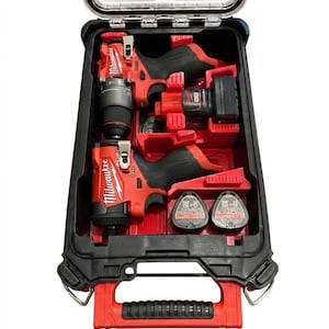 Peut inclure: Une mallette de transport pour outils électriques Milwaukee noire et rouge avec un couvercle transparent, contenant deux outils électriques sans fil rouges et noirs, une batterie et deux composants de batterie dans un insert en plastique rouge.