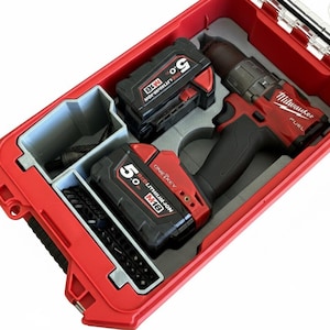 Può includere: Un trapano Milwaukee Fuel rosso con due batterie M18 5.0 REDLITHIUM e un set di punte organizzati in un inserto grigio su misura all'interno di una valigetta rigida rossa con coperchio trasparente e meccanismi di chiusura neri.