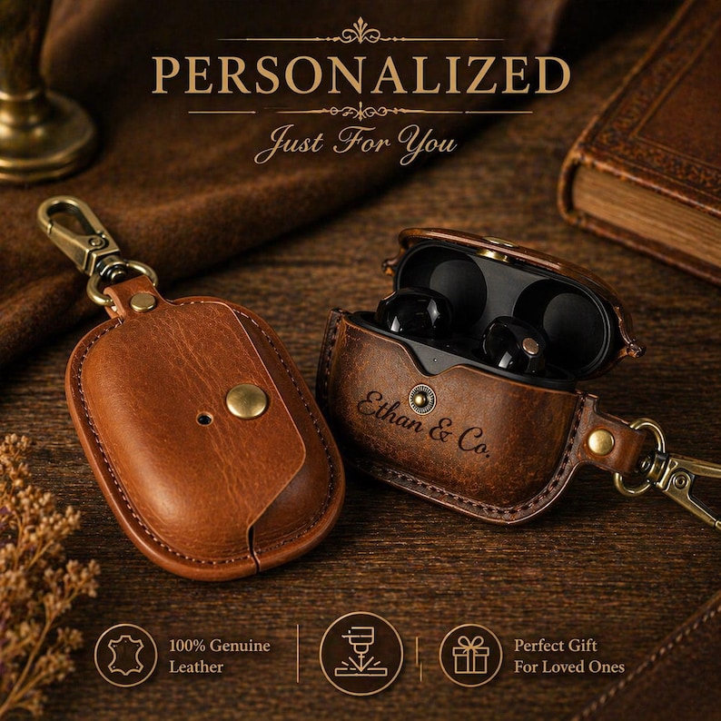 May include: Brown leather earbud case with a gold-colored clasp and the text "Ethan & Co." The case is open, revealing black earbuds. The words "PERSONALIZED" and "Just For You" are at the top.