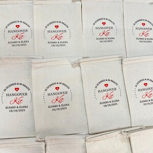 May include: Cream-coloured drawstring bags, each printed with the words "IN SICKNESS & IN HEALTH HANGOVER Kit" in red, along with the names "&Aacute;lvaro & Elena" and the date "18/10/2025".