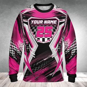 Op de afbeelding: Een shirt met lange mouwen met een race-ontwerp. Het shirt is overwegend roze, zwart en wit, met de tekst "YOUR NAME" boven het nummer "25". Het ontwerp bevat dambordpatronen en bandensporen.