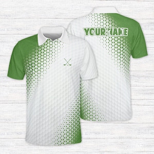 May include: A short-sleeved polo shirt featuring a white and green gradient pattern with a geometric triangle design. The front displays a small icon of two crossed golf clubs and a ball, while the back includes the text YOUR NAME in green.