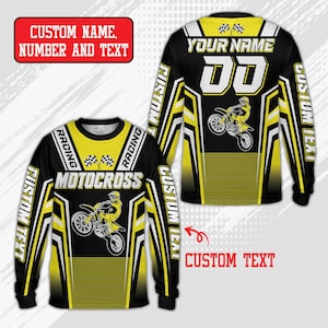 May include: A long-sleeved jersey in black and yellow with a motocross graphic, chequered flags, and the text MOTOCROSS. The design includes placeholders for custom name, number, and text, featuring geometric patterns and racing-themed accents.