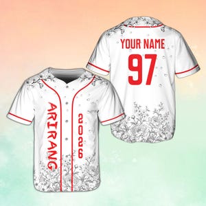 May include: White baseball jersey with red trim and floral design. The front features the word "ARIRANG" vertically and the number "2026". The back has "YOUR NAME" and the number "97" in red.