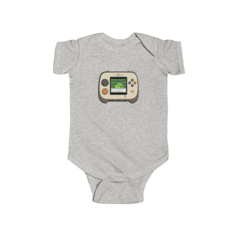May include: A light gray baby bodysuit featuring a retro handheld video game graphic. The game console is beige with colorful buttons and a green screen displaying a pixelated landscape. The bodysuit is made of soft fabric.