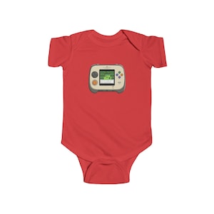 May include: A red baby bodysuit featuring a graphic of a retro handheld video game console. The console is gray and beige with a green screen displaying a pixelated landscape. The bodysuit is made of soft material.