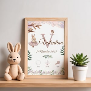 Peut inclure: Un cadre avec le nom "Valentina" et les détails de naissance, avec une illustration de lapin et de hibou. Un jouet en peluche lapin et une plante succulente en pot sont à proximité. L'impression comprend la date "2 Novembre 2025".