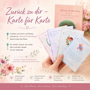 Könnte beinhalten: Eine Hand hält eine Auswahl an illustrierten Karten mit deutschem Text. Die Karten zeigen Aquarelldesigns, darunter ein Pilz, Ballons und florale Elemente. Ein Buch mit dem Titel "Wurzeln & Wandlung" ist sichtbar.