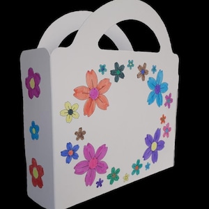 Puede incluir: Una bolsa de regalo de papel blanco con asa, decorada con flores coloridas dibujadas a mano. Las flores son en tonos rosa, naranja, azul, amarillo y verde. La bolsa es rectangular con un asa curva.
